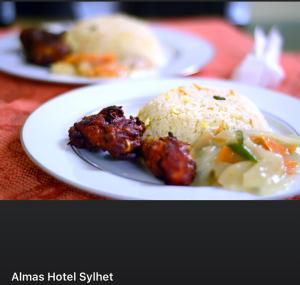 deux assiettes de denrées alimentaires sur une table avec du riz et de la viande dans l'établissement Almas Hotel Sylhet, à Debpur