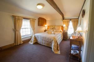 a bedroom with a bed and two windows at The King William IV Country Inn & Restaurant in Sedgeford