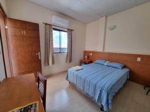 1 dormitorio con cama, mesa y ventana en Hotel Karanda´y en Concepción