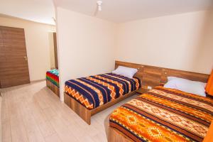a room with two beds in a room at The Traveler Hostel in Otavalo