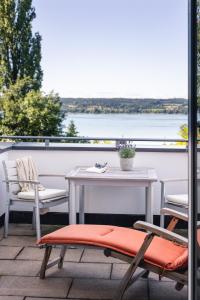 een tafel en stoelen op een balkon met uitzicht op het water bij Kurviertel Wohnung I in Überlingen