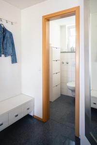een badkamer met een wastafel, een toilet en een spiegel bij Kurviertel Wohnung I in Überlingen +3 foto's