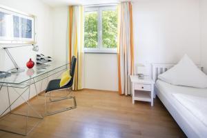 een slaapkamer met een bed en een bureau en een bed bij Kurviertel Wohnung I in Überlingen