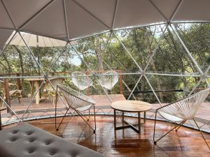 a patio with chairs and a table and an umbrella at Solana Glamping in Pereira