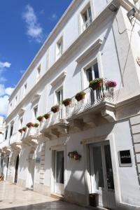 un edificio blanco con macetas en los balcones en Casa Masaniello, en Martina Franca
