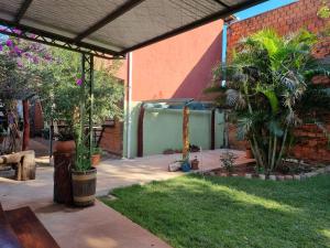 a patio with plants and a brick building at Hotel Karanda´y in Villa Concepción