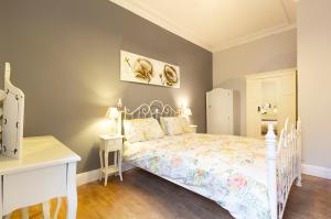 1 dormitorio con cama blanca y escritorio blanco en Cosy near centre Edinburgh apartment, en Edimburgo