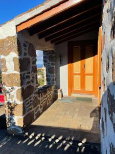 an entrance to a stone building with a orange door at Casa Gabriela in Puntallana