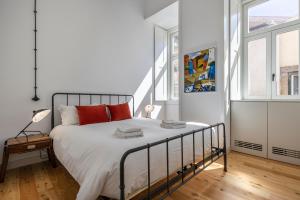 una camera bianca con un grande letto con cuscini rossi di Glamorous 3BDR Apartment in City Center by LovelyStay a Lisbona