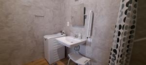 a white bathroom with a sink and a mirror at Apartamenty Nad Stawem in Powidz +17 photos