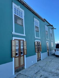 un edificio azul con una furgoneta estacionada frente a él en Casa Gabriela en Puntallana