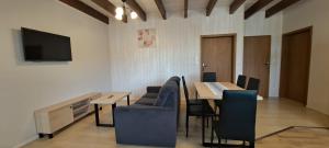 a dining room with a table and chairs and a tv at Apartament Nad Stawem in Powidz