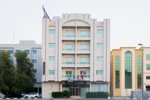 um grande edifício branco com uma varanda em Sea Shore Hotel Apartment Khorfakkan em Khor Fakkan