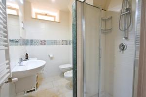 ein Bad mit einer Dusche, einem Waschbecken und einem WC in der Unterkunft Casa Masaniello in Martina Franca