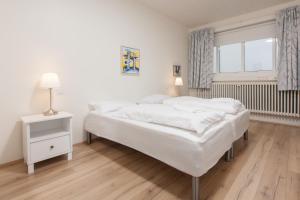 ein weißes Schlafzimmer mit einem großen Bett und einem Fenster in der Unterkunft Ljosafoss Guest House in Selfoss