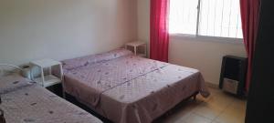 a small bedroom with two beds and a window at Casa Villa del Lago in Villa Carlos Paz