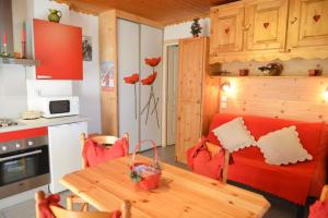 a kitchen and dining room with a table and red chairs at Studio avec jardin clos et wifi a Valloire a 3 km des pistes in Valloire