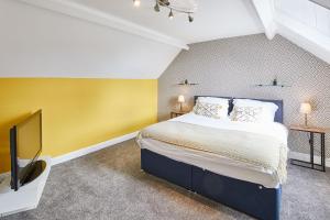 a bedroom with a large bed and a tv at Host & Stay - Seagull Cottage in Bridlington