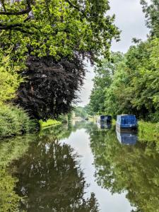 a river with two boats in the water at Narrow Escape - 50ft Boat on the Grand Union Canal, near Tring in Tring