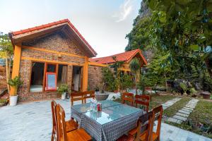 un patio con mesa y sillas frente a una casa en Tam Coc mountain bungalow en Ninh Binh