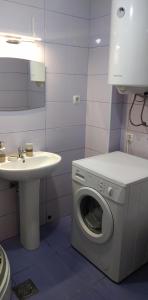 uma casa de banho com uma máquina de lavar roupa e um lavatório em Lovely condo next to salt room, bus station em Skopje