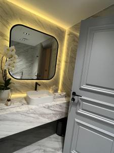 a bathroom with a sink and a mirror at The Key - Luxury Apartment in Doha