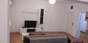 a living room with a couch and a tv at Lovely condo next to salt room, bus station in Skopje