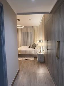 a bedroom with a bed and a table in a room at The Key - Luxury Apartment in Doha