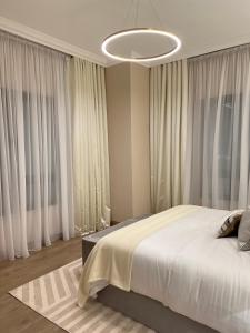 a bedroom with a large bed with white curtains at The Key - Luxury Apartment in Doha