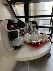 ローマにあるラグジュアリー オン ザ リバーのコーヒーメーカー、テーブルの上のカップ