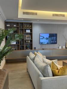 a living room with a couch and a flat screen tv at The Key - Luxury Apartment in Doha