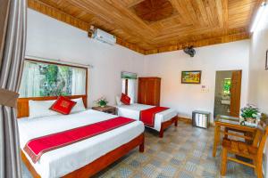 a hotel room with two beds and a window at Tam Coc mountain bungalow in Ninh Binh