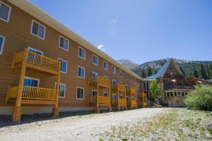 a large building with wooden balconies on a dirt road at Located At Base Of The Magnificent Mt Quandary in Breckenridge