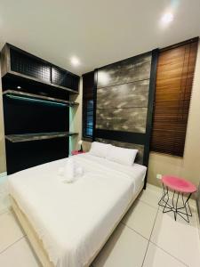 een slaapkamer met een groot wit bed en een roze stoel bij Kulai Lagenda Putra Corner House 古来公主城民宿 near JPO in Kulai