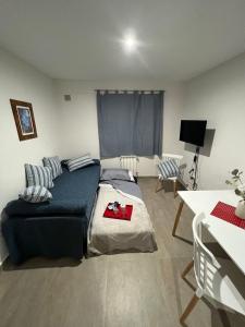 ein Schlafzimmer mit einem Bett und ein Wohnzimmer mit einem Tisch in der Unterkunft M&C Apart in Salta