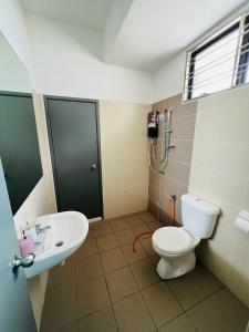 ein Bad mit einem WC und einem Waschbecken in der Unterkunft Kulai Lagenda Putra Corner House 古来公主城民宿 near JPO in Kulai