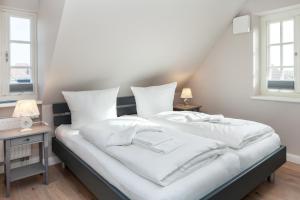 a large white bed with white sheets and pillows at Moin Moin in List