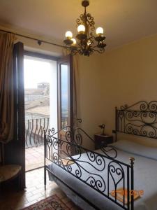 um quarto com uma cama com um lustre e uma varanda em Castello di Altomonte em Altomonte