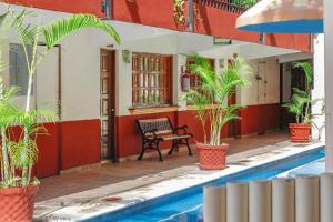 a house with a bench next to a swimming pool at Hotel Hacienda María Eugenia in Acapulco