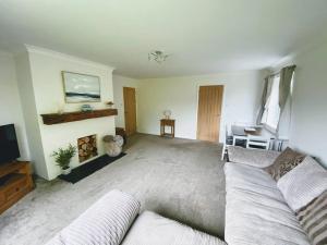 a living room with a couch and a fireplace at Cosy bungalow in countryside village near coast in Pembroke