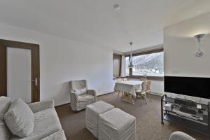 Chesa Arlas - St. Moritz في سان موريتز: غرفة معيشة مع أريكة وطاولة