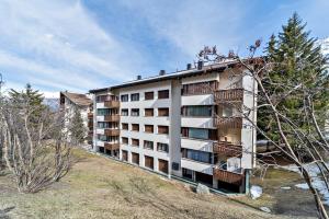Chesa Arlas - St. Moritz في سان موريتز: مبنى شقق على تلة فيها اشجار