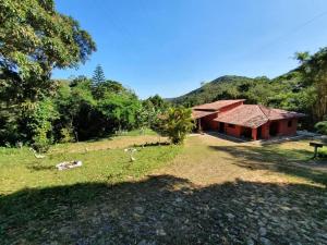 een huis in een veld naast een bos bij Linda casa com banho natural em Guaramiranga in Guaramiranga