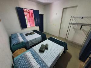 2 Betten in einem Zimmer mit 2 Paar Schuhen in der Unterkunft Linda casa com banho natural em Guaramiranga in Guaramiranga