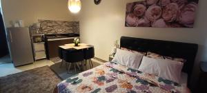 a bedroom with a bed and a table and a kitchen at Katliza Condotel Kassel Residences in Manila