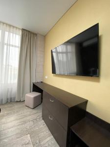 a hotel room with a flat screen tv on the wall at Hotel Atmosphere in Poltava