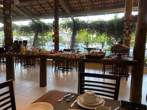 un restaurante con mesas y sillas y una mesa con comida en Flex Hotel, en Canoinhas