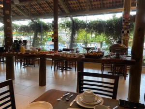 a restaurant with tables and chairs and a table with food at Flex Hotel in Canoinhas
