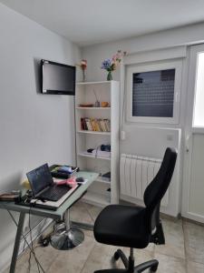 escritorio con ordenador portátil y silla en la habitación en T1 meublé, en Saint-Chamond
