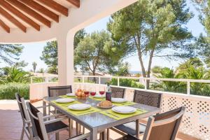 a dining table and chairs on the patio of a house at Villa Amapola by Villa Plus in Santo Tomás